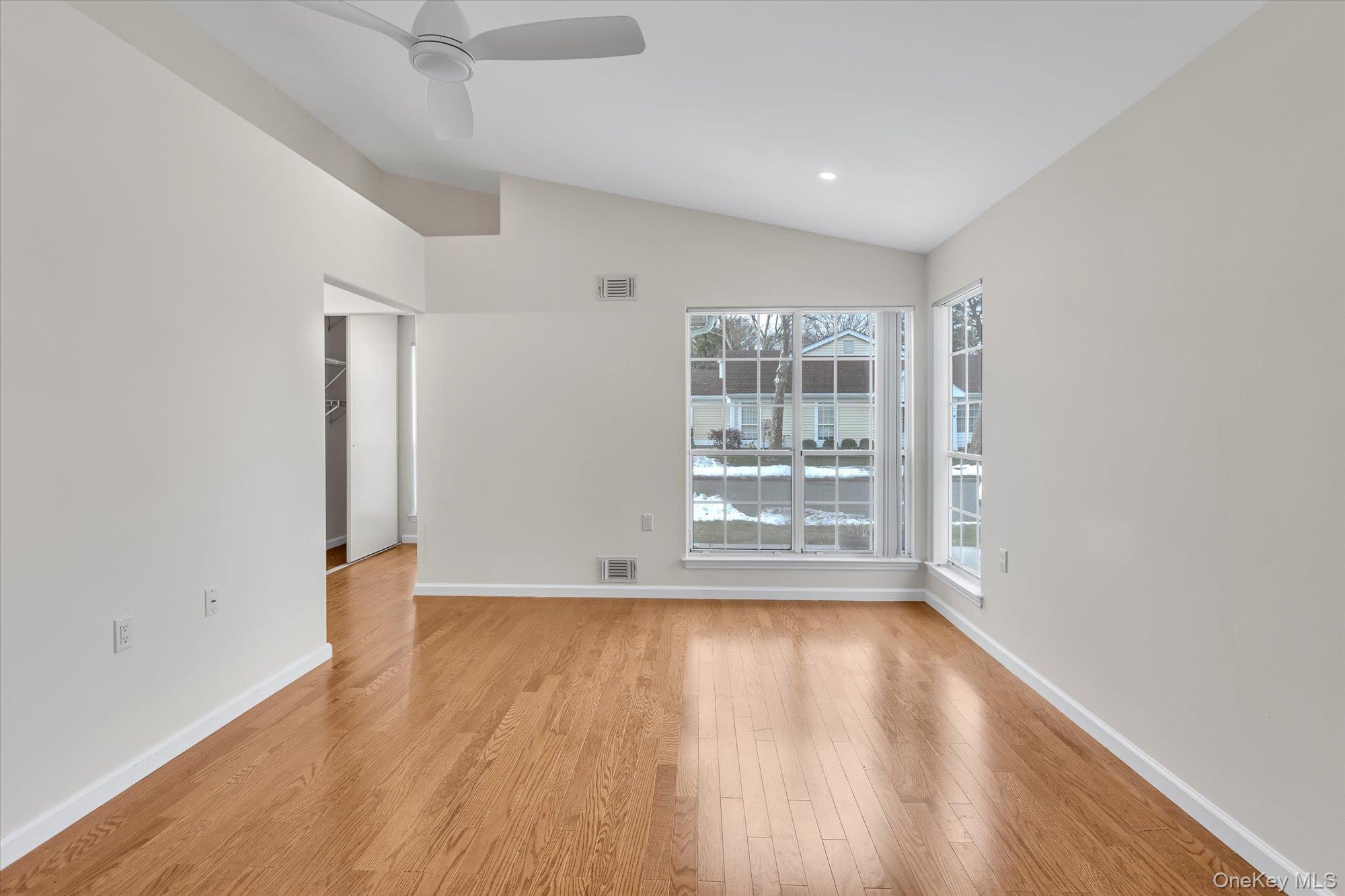 289 Glen Drive Ridge, NY 11961 - Photo 12 of 19 an empty room with wooden floor and windows