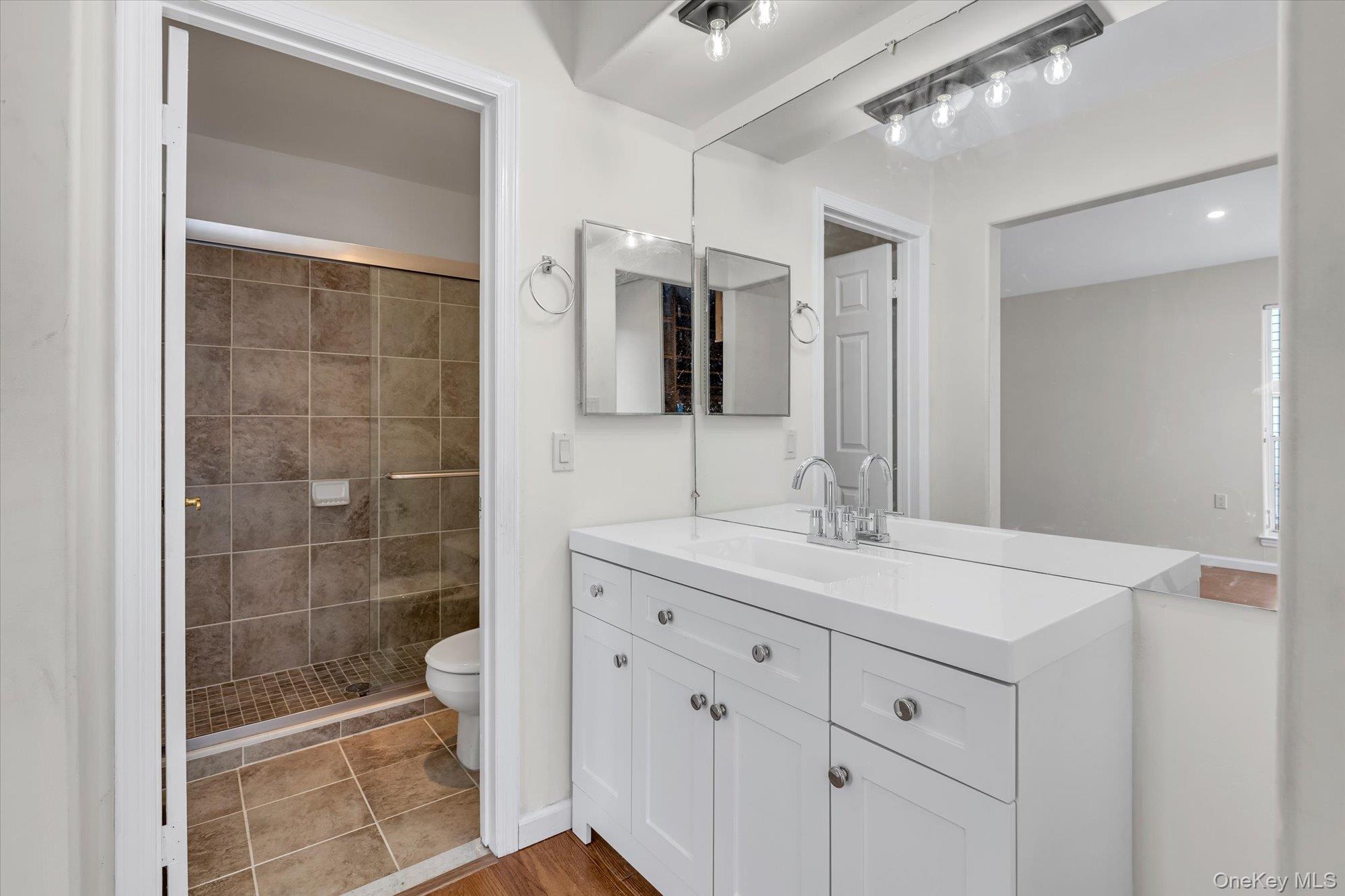 289 Glen Drive Ridge, NY 11961 - Photo 14 of 19 a bathroom with a shower sink and mirror
