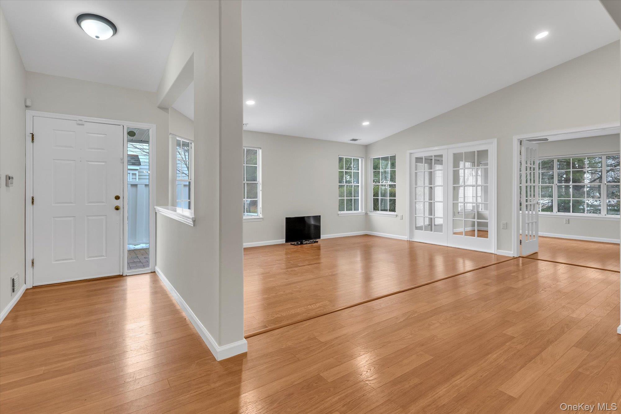 289 Glen Drive Ridge, NY 11961 - Photo 2 of 19 a view of empty room with wooden floor and floor to ceiling window