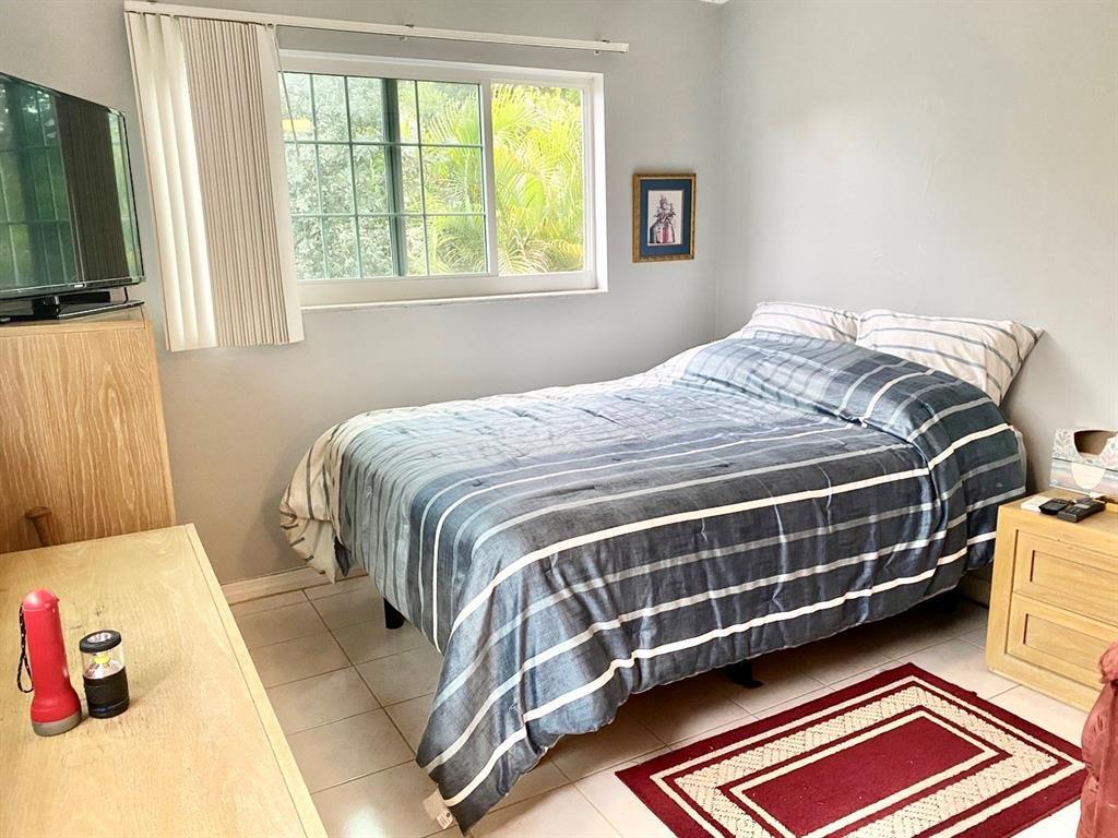 3002 Northeast 5th Terrace, Unit 209B Wilton Manors, FL 33334 - Photo 13 of 25 a bed sitting in a bedroom next to a window