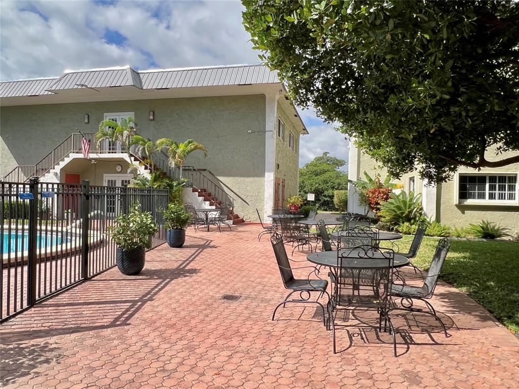 3002 Northeast 5th Terrace, Unit 209B Wilton Manors, FL 33334 - Photo 20 of 25 a view of a patio with table and chairs potted plants