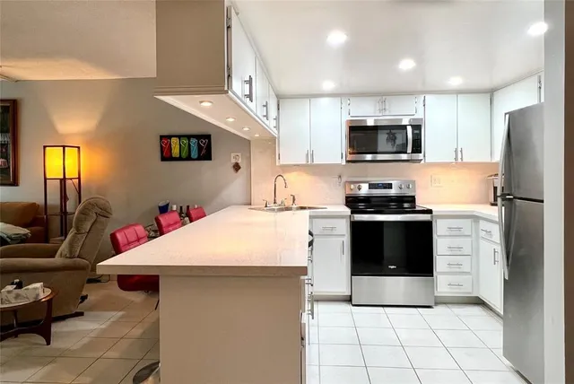 a kitchen with a sink a microwave a refrigerator and cabinets