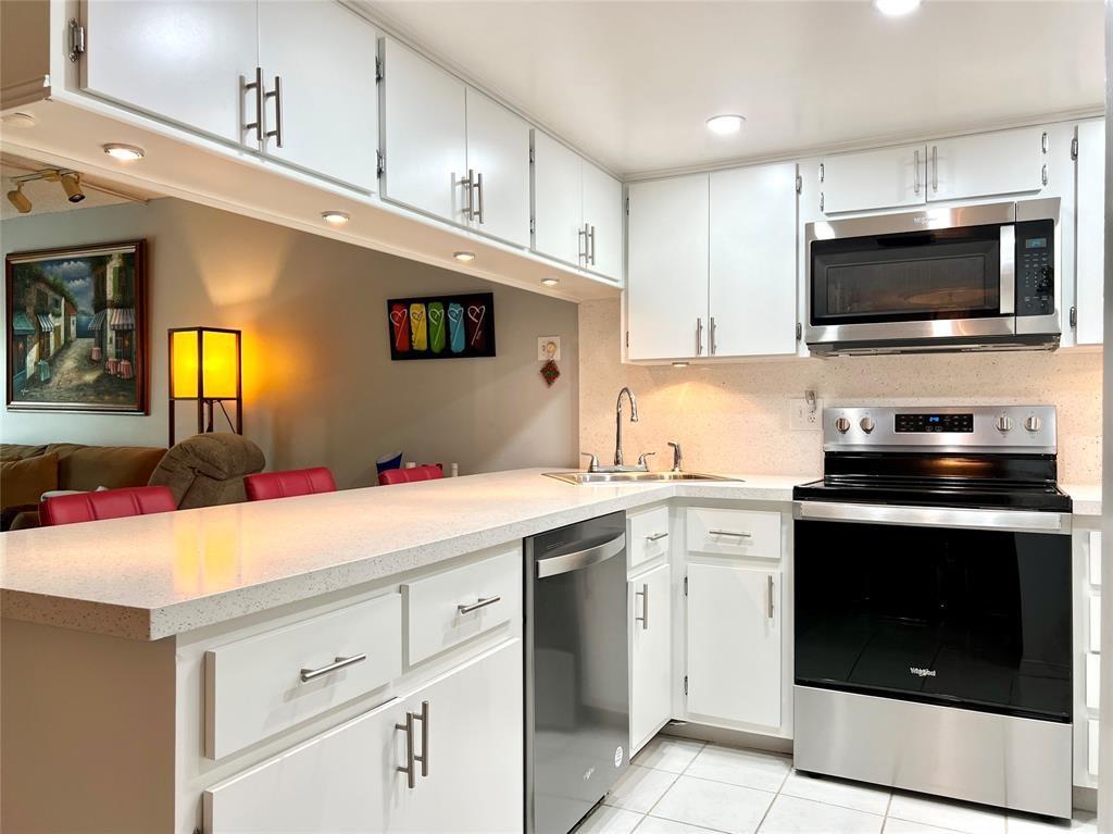 3002 Northeast 5th Terrace, Unit 209B Wilton Manors, FL 33334 - Photo 5 of 25 a kitchen with a sink stove and microwave