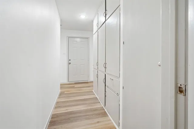 a view of a hallway with wooden floor and staircase