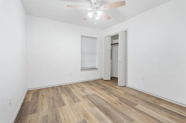 an empty room with a fan and a window