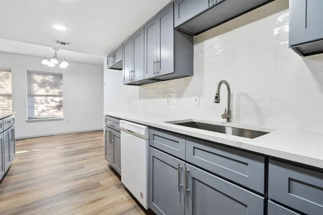 a kitchen with stainless steel appliances granite countertop a sink dishwasher a refrigerator and wooden cabinets