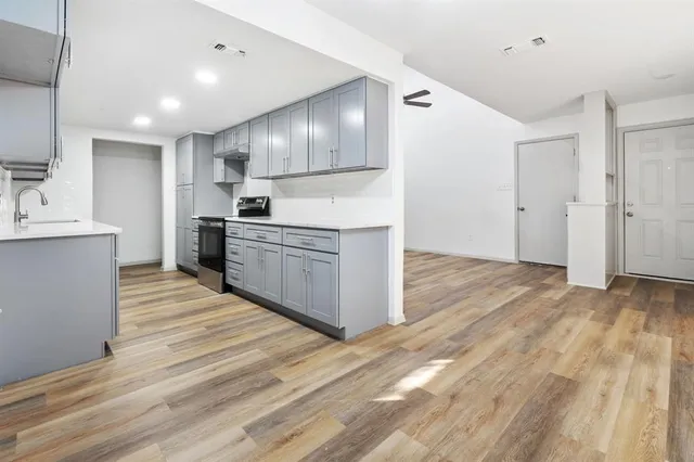 a large kitchen with stainless steel appliances granite countertop a stove and a sink