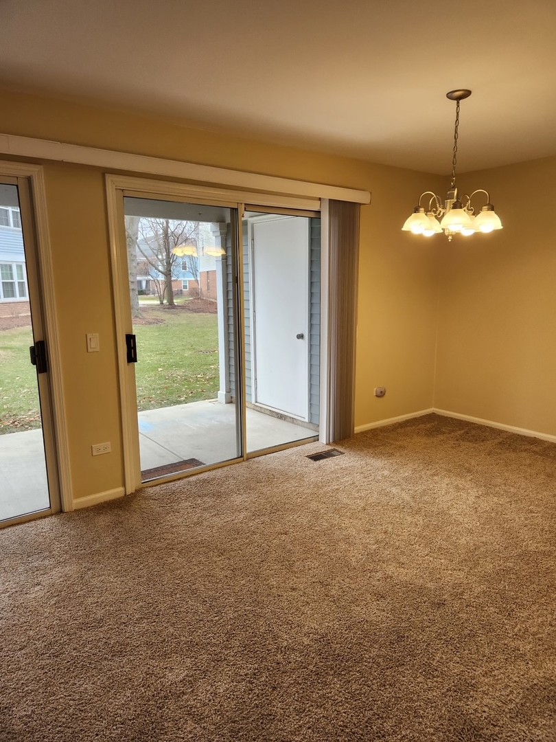 1403 Plum Court, Unit B Mount Prospect, IL 60056 - Photo 3 of 12 a view of an empty room with a window