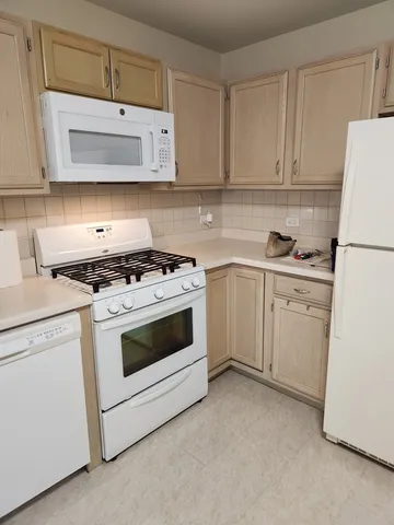 a kitchen with white cabinets and white appliances