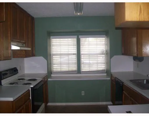 a kitchen with a sink a stove and a window