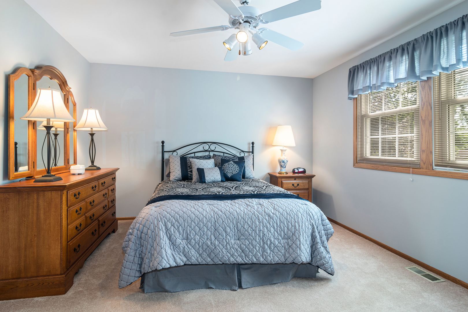 73 Foxcroft Road Naperville, IL 60565 - Photo 22 of 37 a bedroom with a bed a mirror on dresser and a chandelier