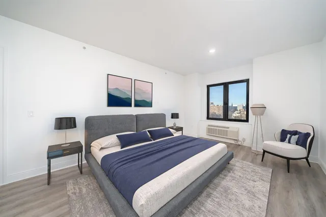 a view of a room with wooden floor and mirror