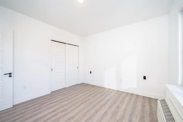 a living room with a couch and lamp on the wooden floor