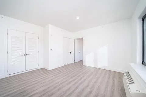 a view of an empty room with wooden floor
