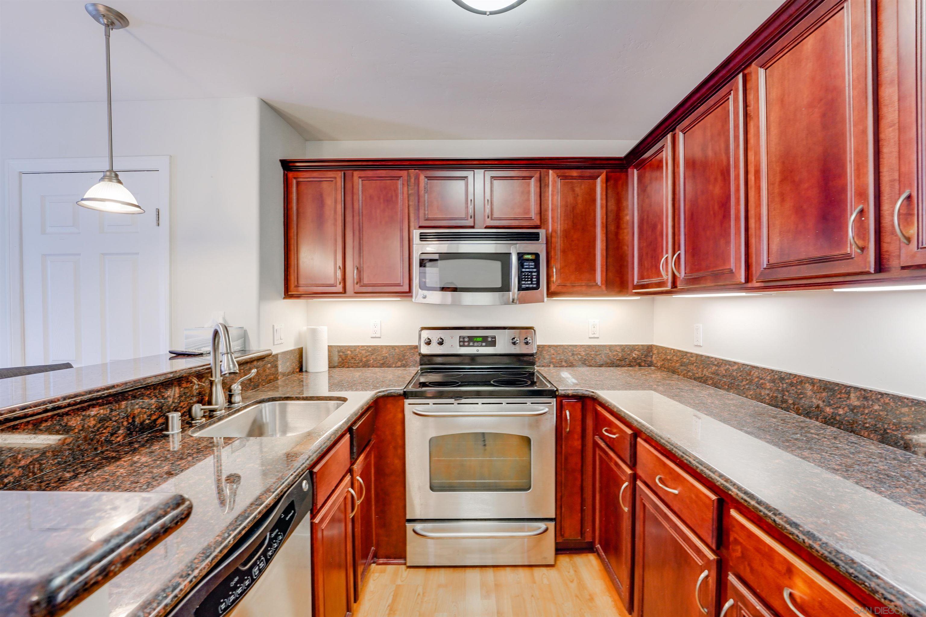 a kitchen with granite countertop a sink stove and cabinets
