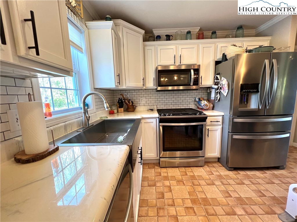 1534 Longhope Road Todd, NC 28684 - Photo 7 of 35 a kitchen with stainless steel appliances a stove a sink and a refrigerator