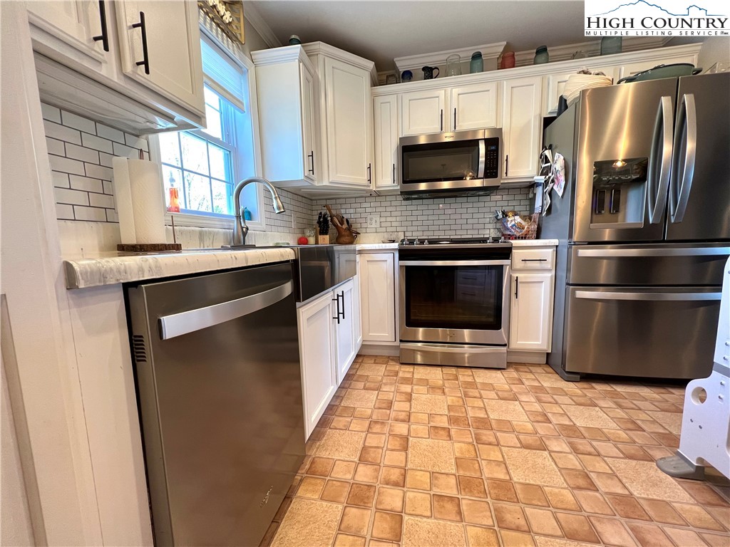 1534 Longhope Road Todd, NC 28684 - Photo 8 of 35 a kitchen with stainless steel appliances granite countertop a stove a sink and a microwave