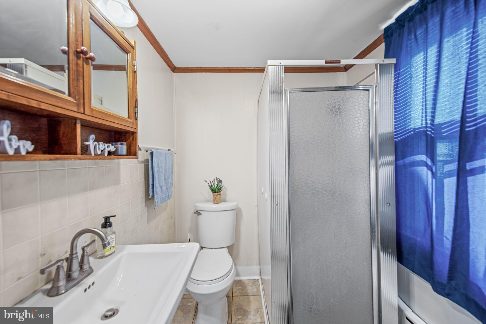 817 Locust Street Cambridge, MD 21613 - Photo 22 of 44 a white toilet sitting next to a bathroom sink