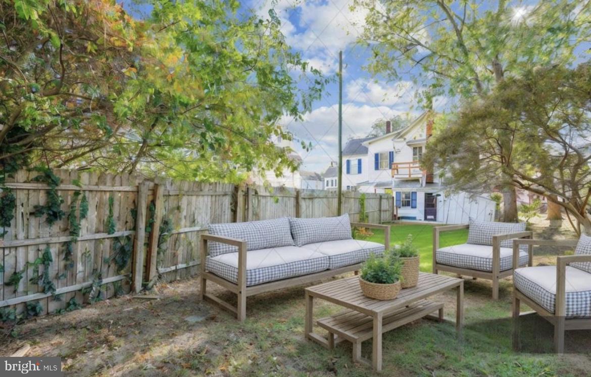 817 Locust Street Cambridge, MD 21613 - Photo 27 of 44 a view of a patio with couches and a fire pit and wooden fence