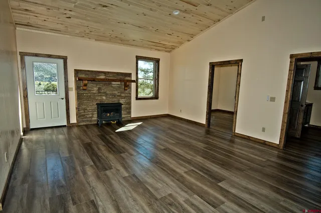 a view of empty room with wooden floor and fireplace