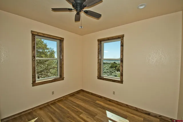 a view of an empty room with a window and a ceiling fan