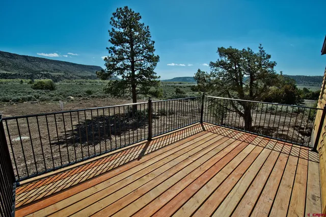 a view of balcony with wooden floor and fence