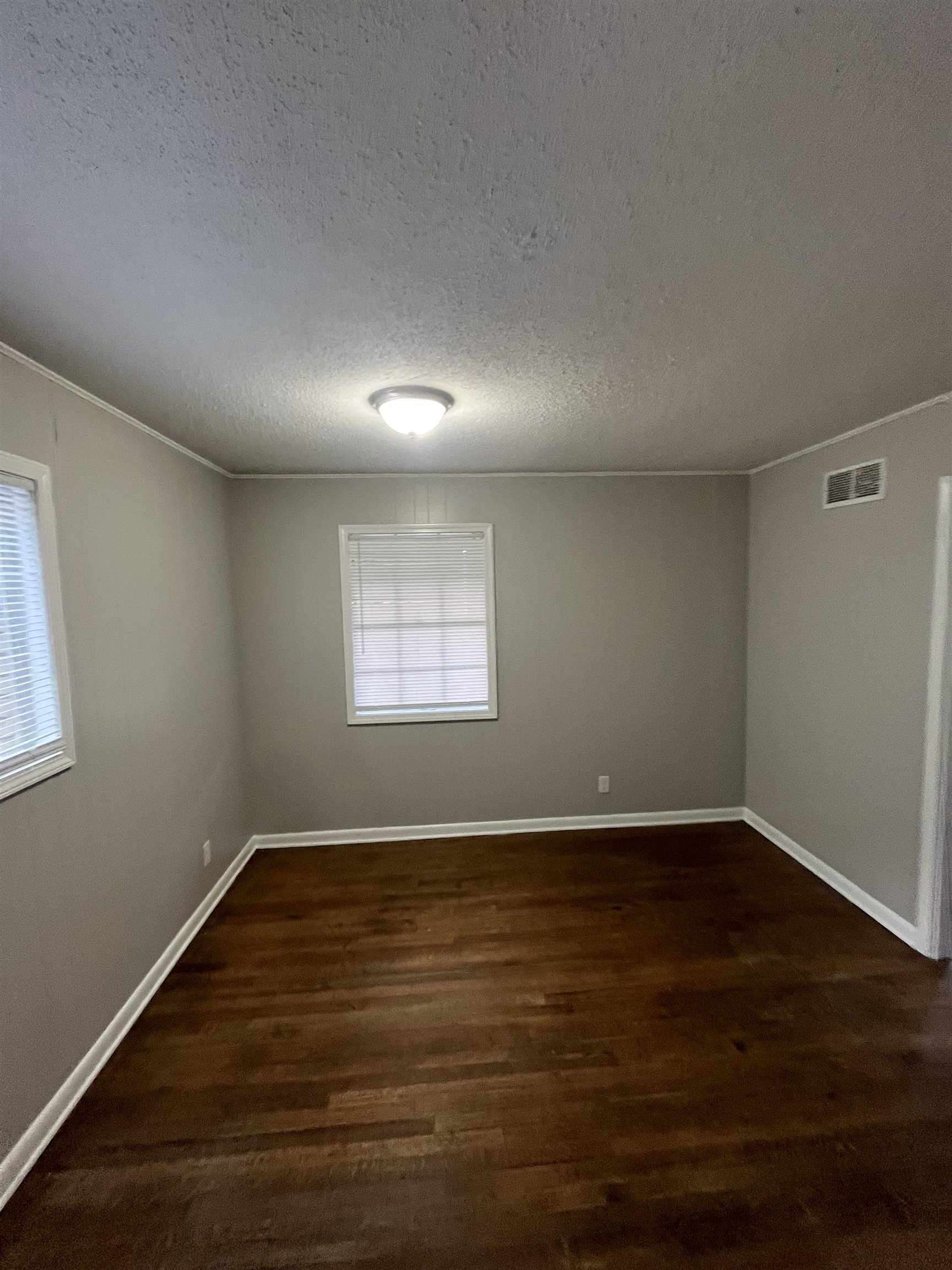 4173 Cottonwood Road Memphis, TN 38118 - Photo 4 of 13 Unfurnished room with dark wood-style floors and a textured ceiling