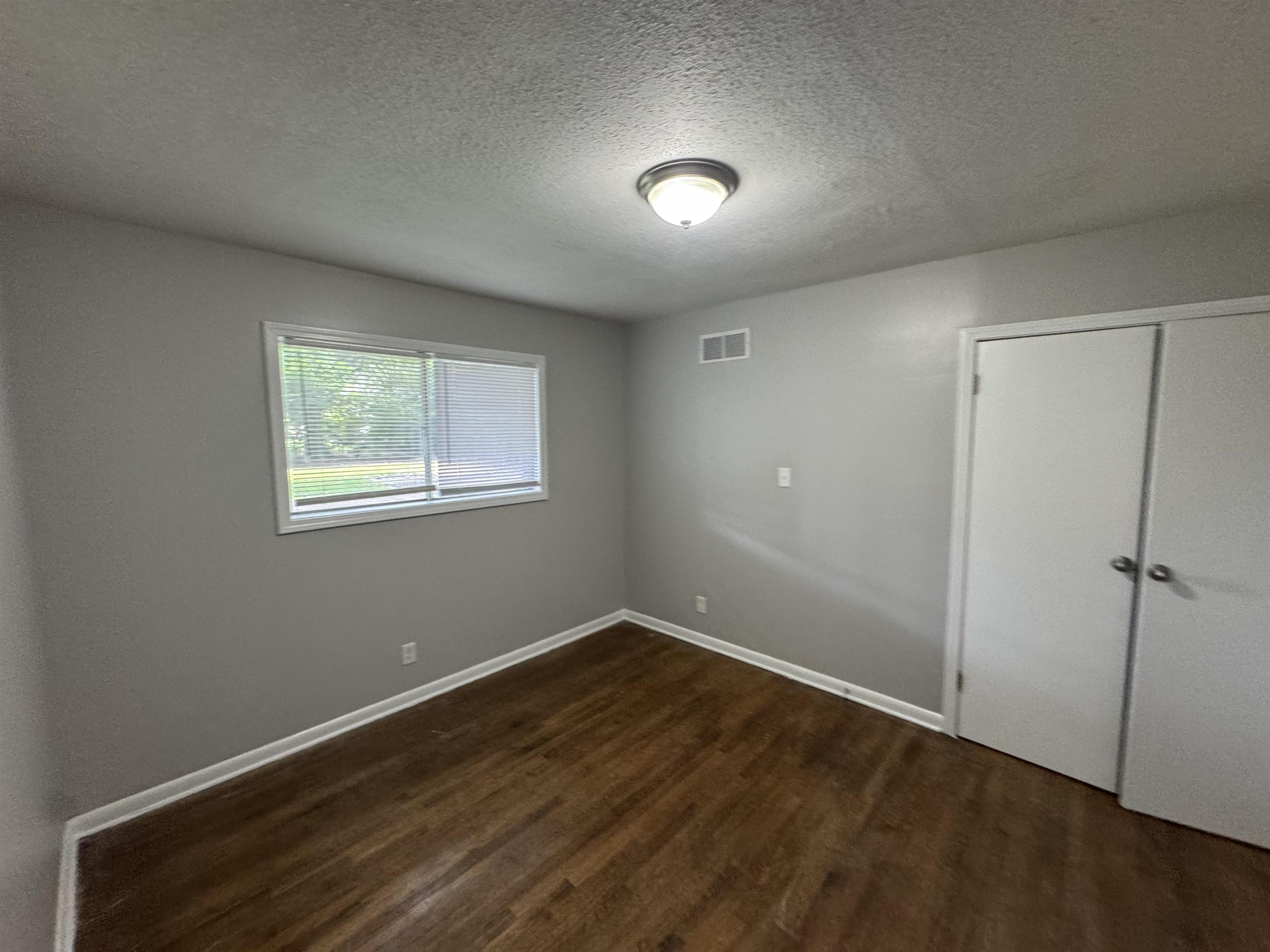 4173 Cottonwood Road Memphis, TN 38118 - Photo 4 of 13 an empty room with wooden floor and window