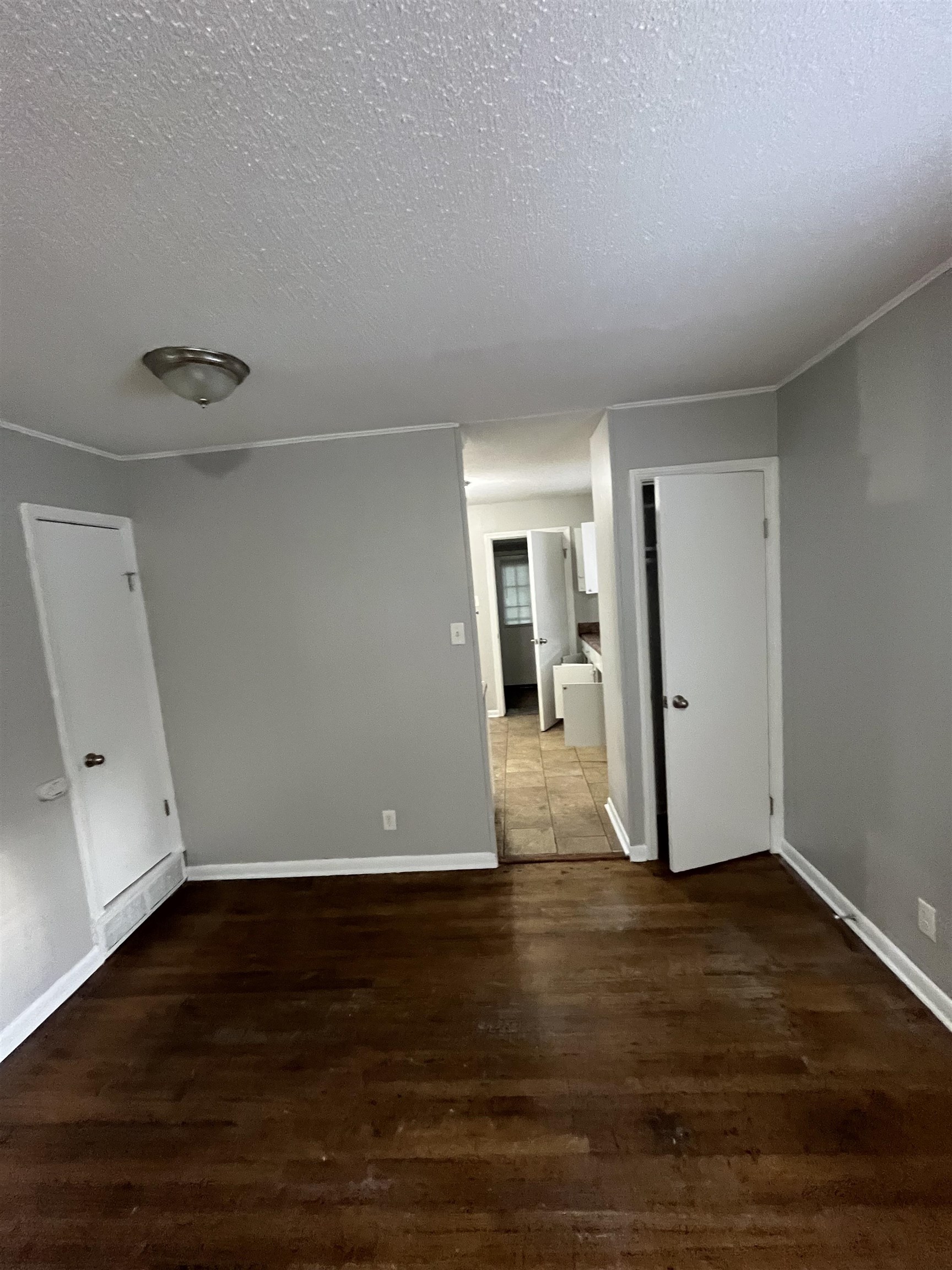 4173 Cottonwood Road Memphis, TN 38118 - Photo 5 of 13 Spare room with a textured ceiling and dark wood-style flooring