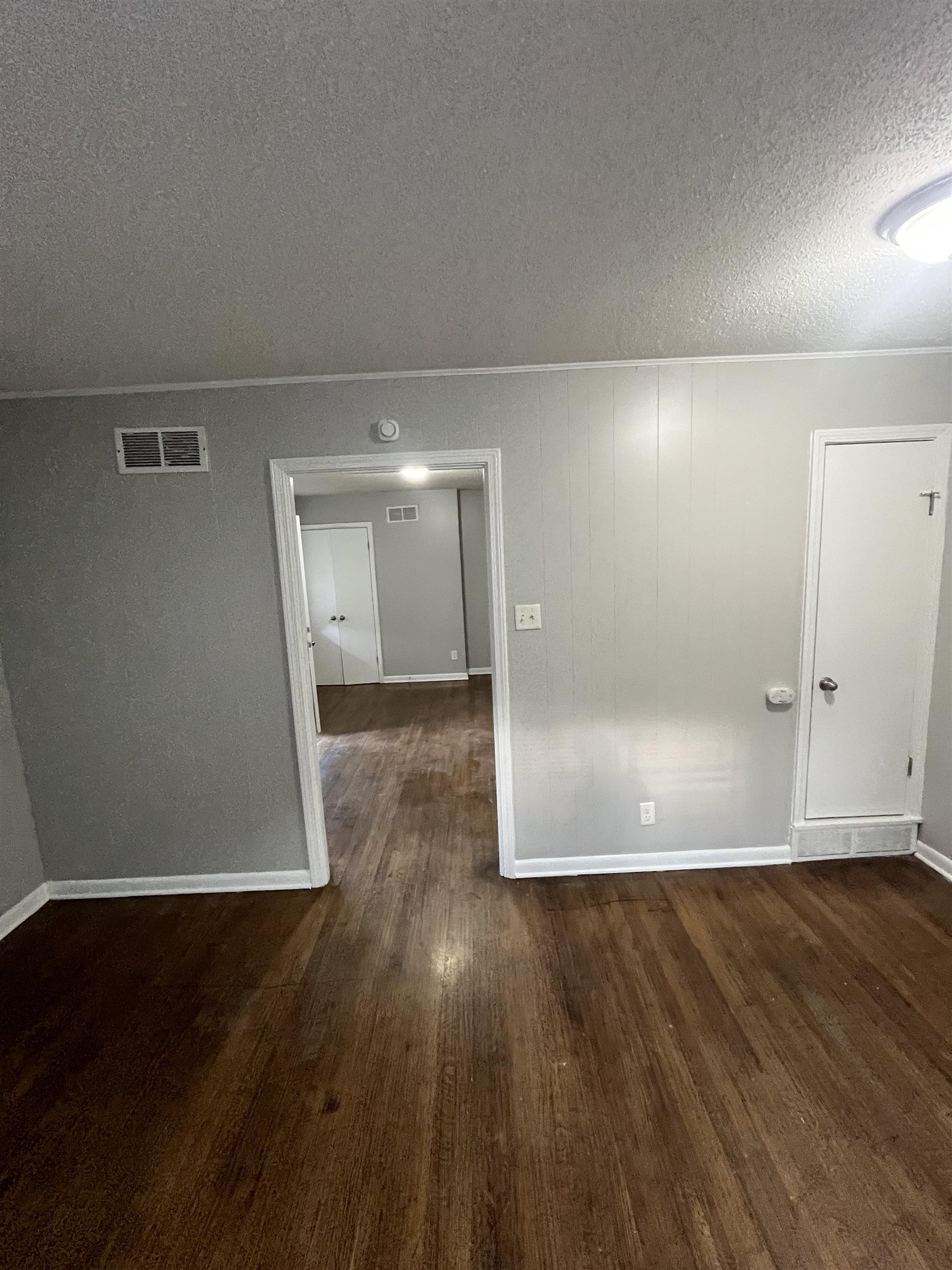 4173 Cottonwood Road Memphis, TN 38118 - Photo 6 of 13 Spare room with dark wood-type flooring and a textured ceiling