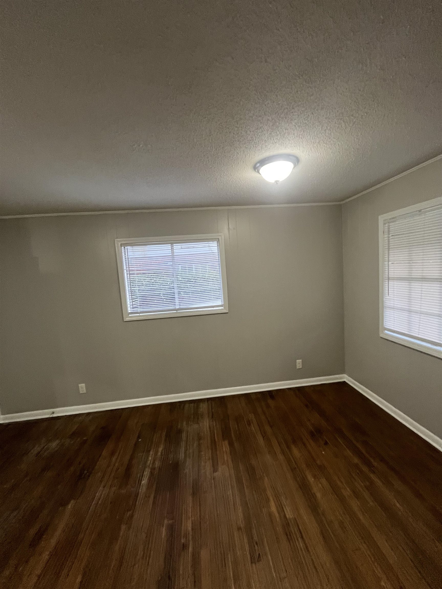 4173 Cottonwood Road Memphis, TN 38118 - Photo 7 of 13 Empty room featuring a textured ceiling and dark wood-style flooring