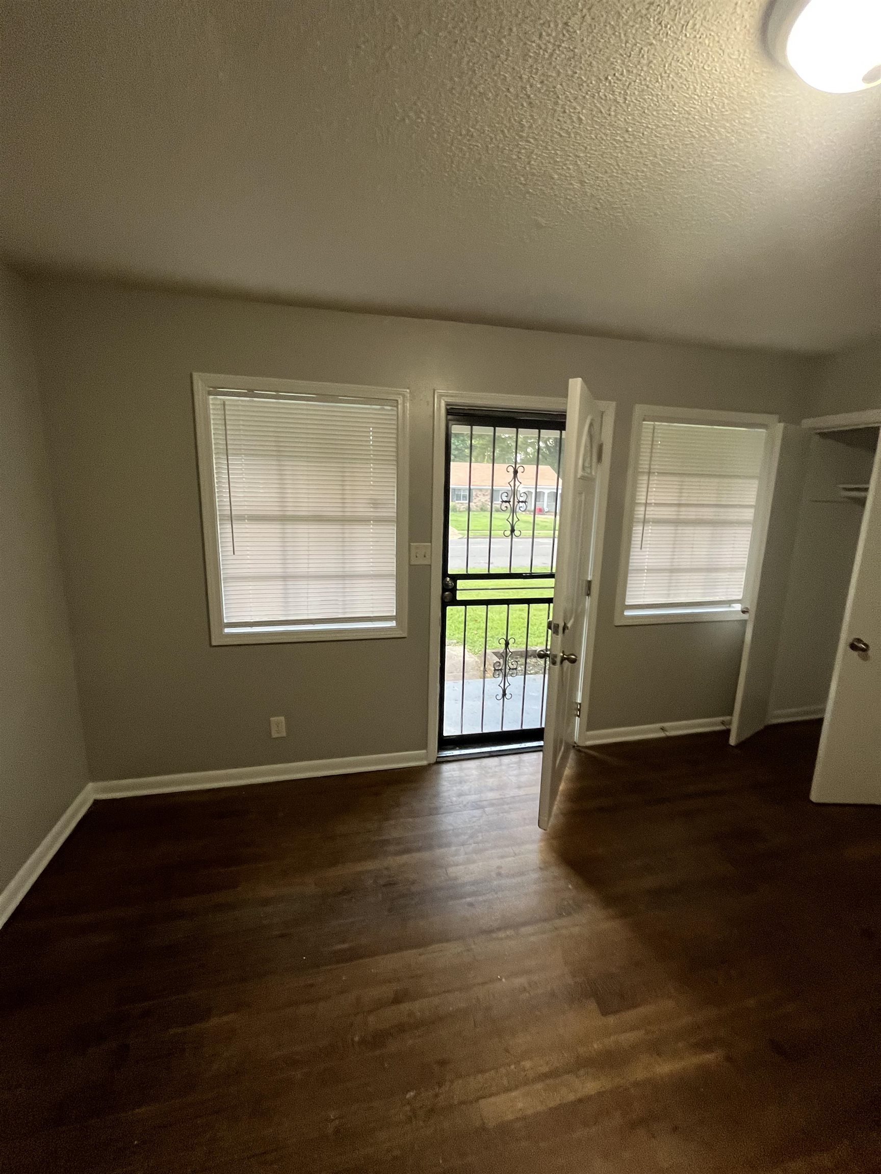 4173 Cottonwood Road Memphis, TN 38118 - Photo 9 of 13 Spare room with a textured ceiling and dark wood-style floors