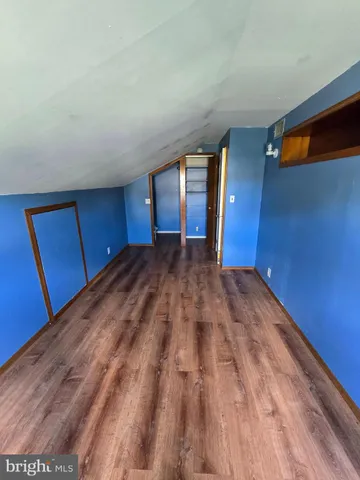 a view of empty room with window and wooden floor