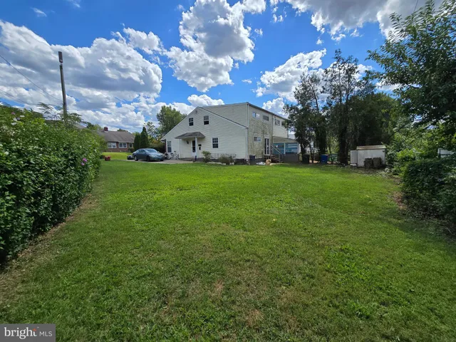 a view of a house with a big yard and a large tree