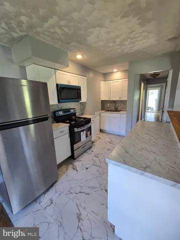a kitchen with stainless steel appliances granite countertop a refrigerator a sink a stove and dishwasher