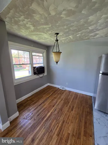 a view of empty room with wooden floor and window