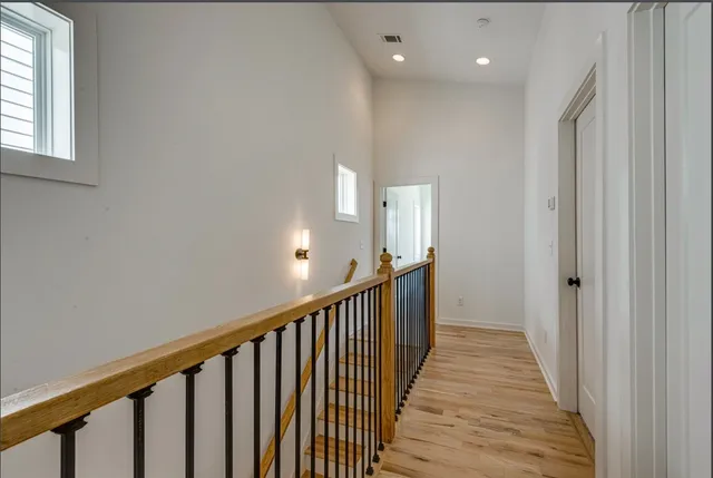 a view of a hallway with wooden floor and entryway