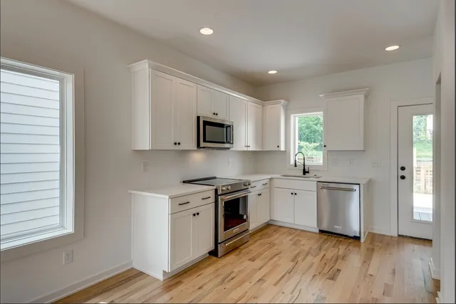 a kitchen with a stove a sink and a microwave