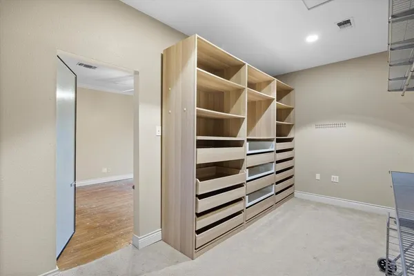 a view of walk in closet with empty racks