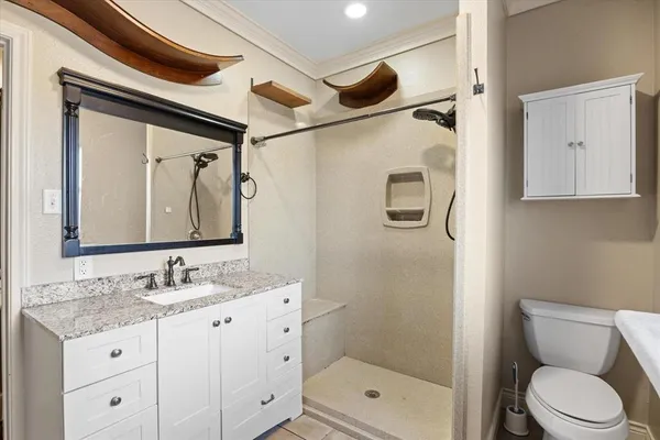 a bathroom with a granite countertop sink toilet and shower