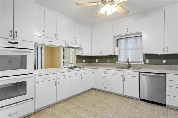 a kitchen with granite countertop white cabinets stainless steel appliances and sink