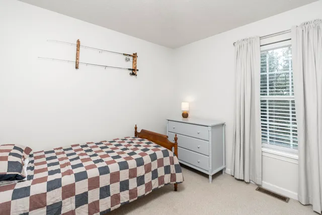 a bedroom with a bed and a large window