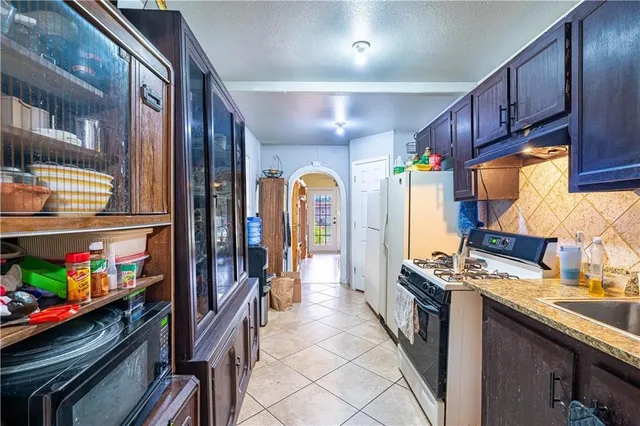 a kitchen with stainless steel appliances granite countertop a refrigerator and a stove