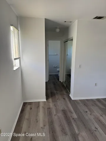 an empty room with wooden floor and a window