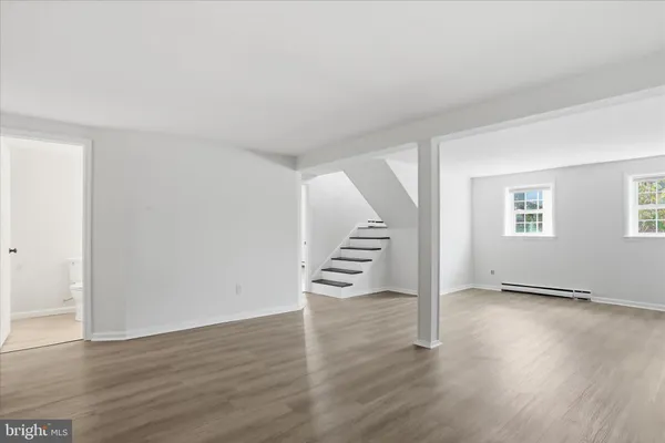 an empty room with wooden floor and stairs