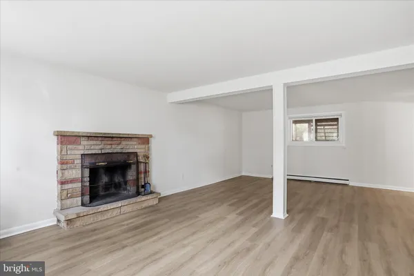 an empty room with wooden floor and fireplace