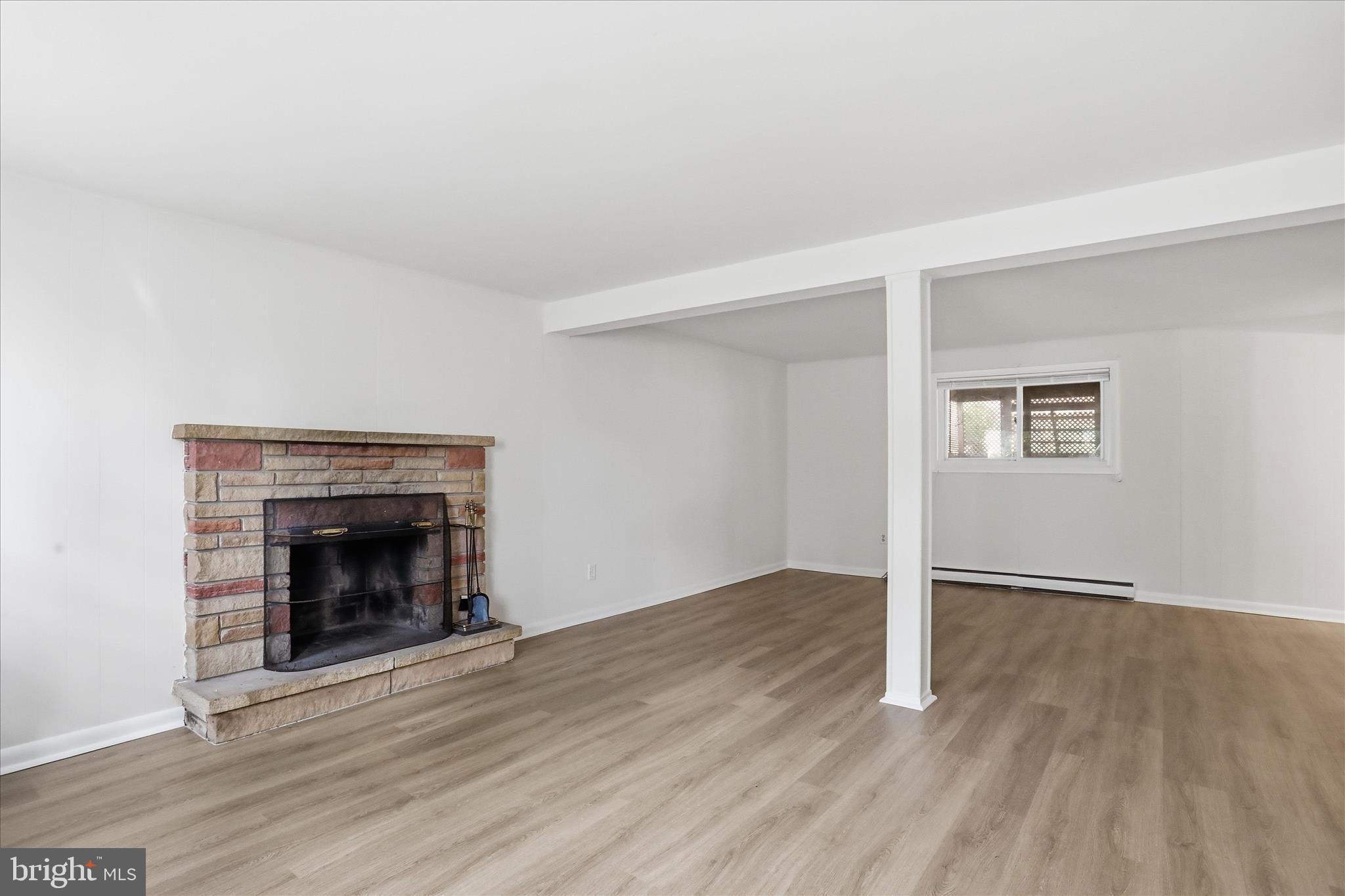 19022 Longmeadow Road Hagerstown, MD 21742 - Photo 20 of 30 an empty room with wooden floor and fireplace