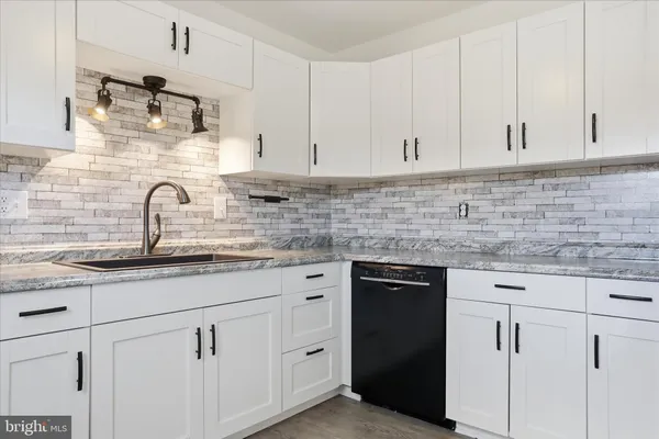a kitchen with white cabinets and a sink