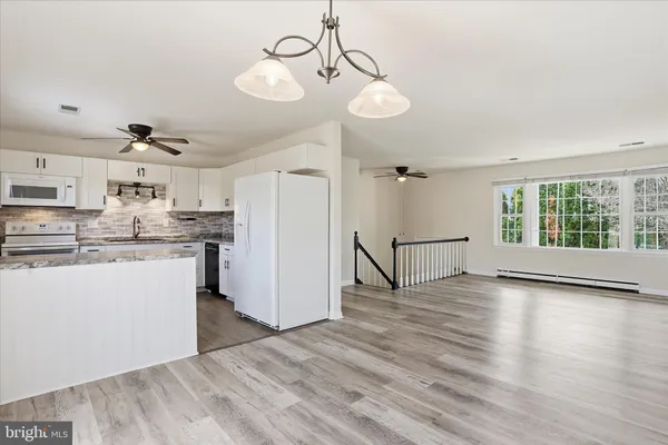 a view of a kitchen with wooden floor and a refrigerator