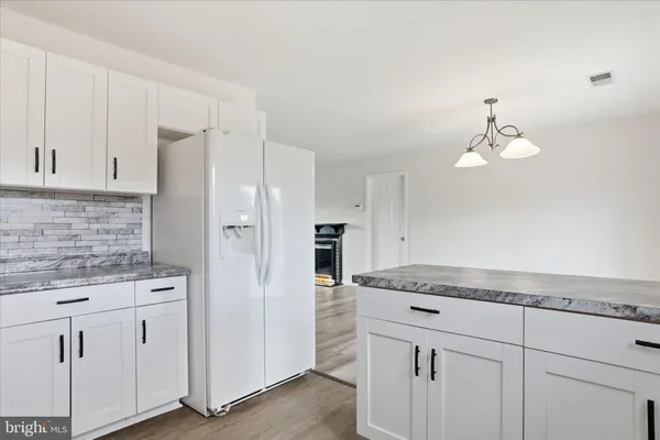 a kitchen with white cabinets and refrigerator